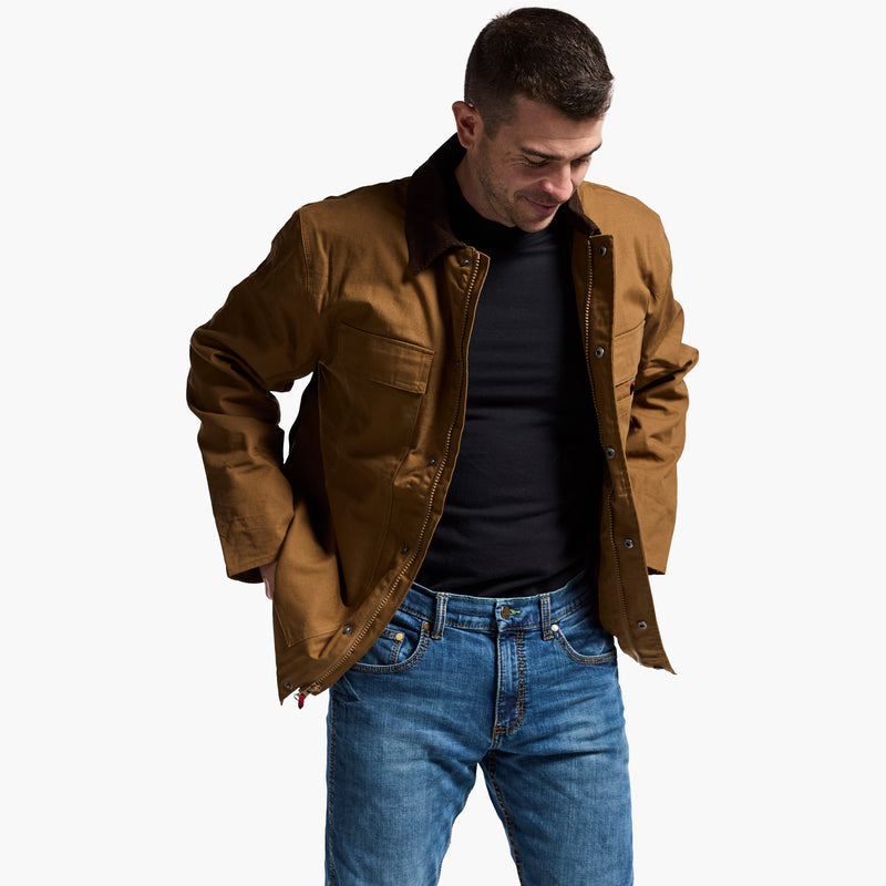 Man wearing a brown jacket and blue jeans on a white background