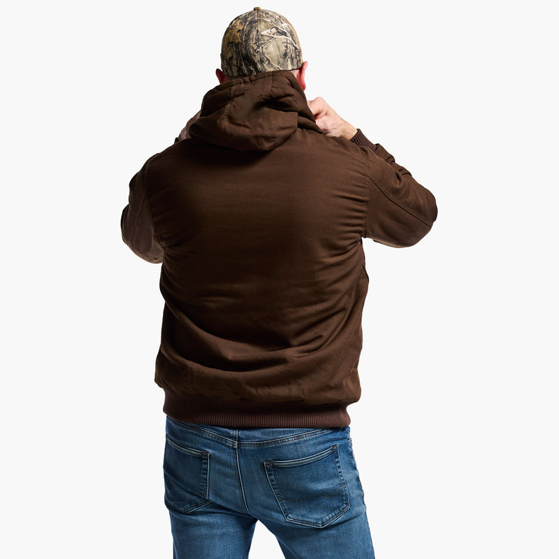 Person wearing a brown hoodie and blue jeans with a camouflage-patterned cap on a white background