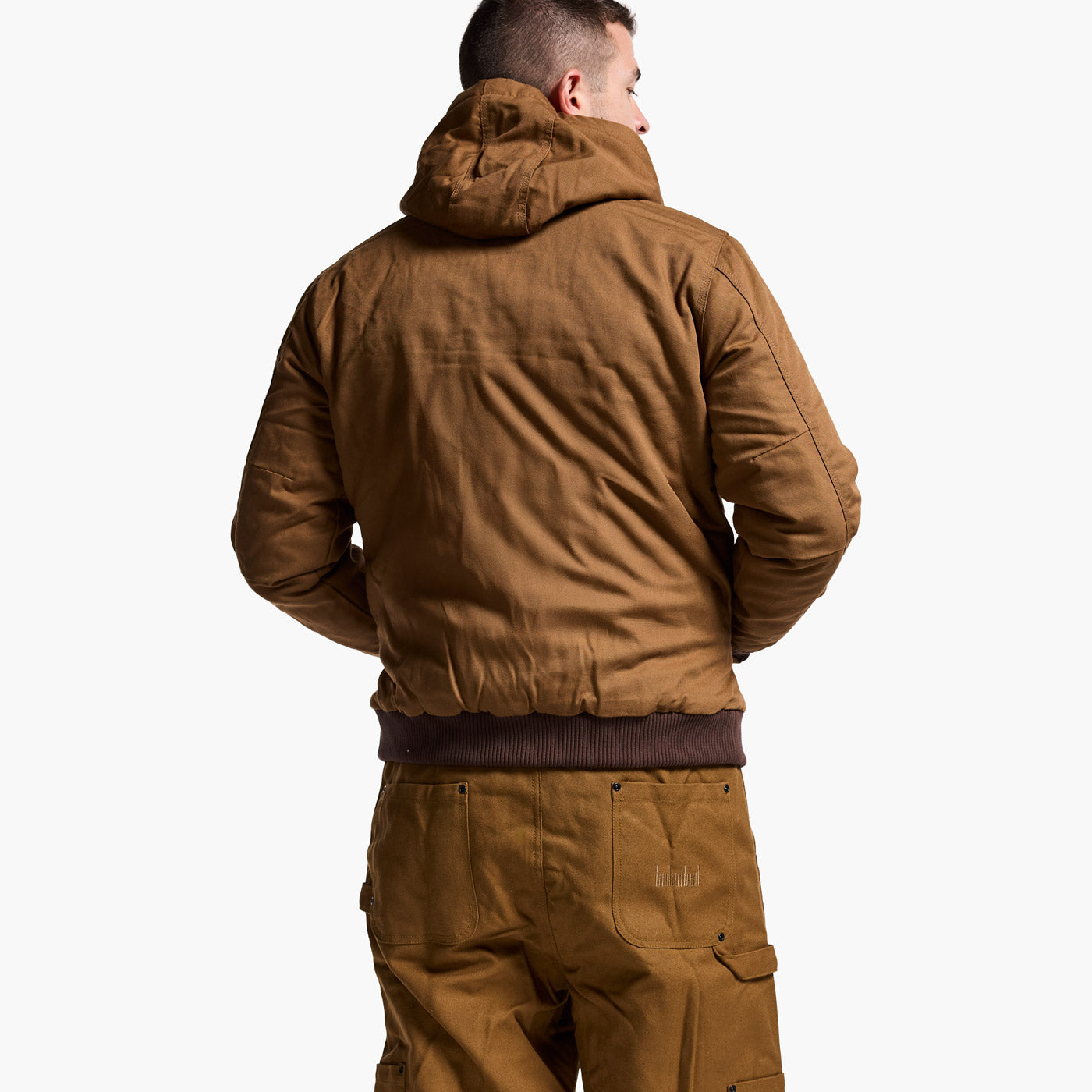 Person wearing a brown jacket and pants on a white background