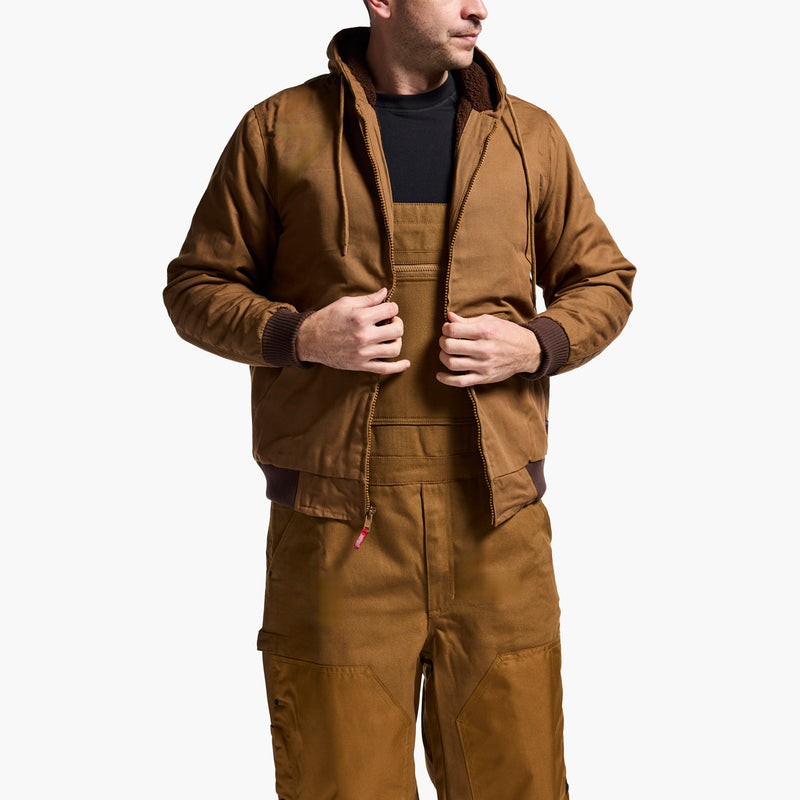 Man wearing a brown jacket and overalls on a white background