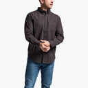 Man wearing a dark brown shirt and blue jeans on a white background