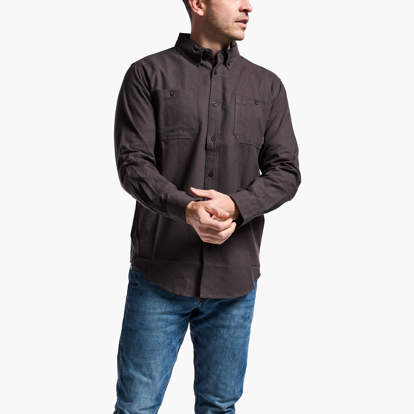 Man wearing a dark brown shirt and blue jeans on a white background