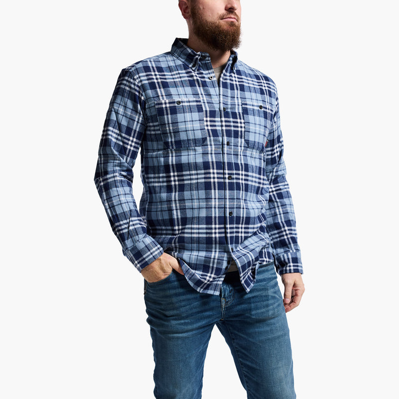 Man wearing a blue plaid shirt and jeans on a white background