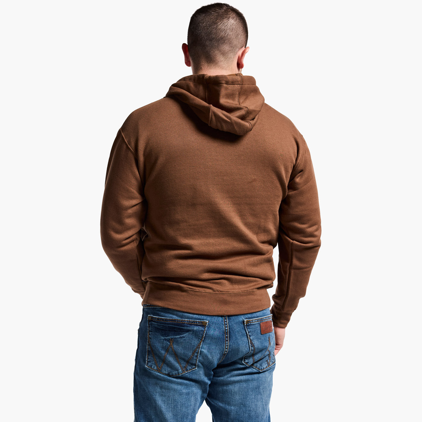 Man wearing a brown hoodie and blue jeans on a white background