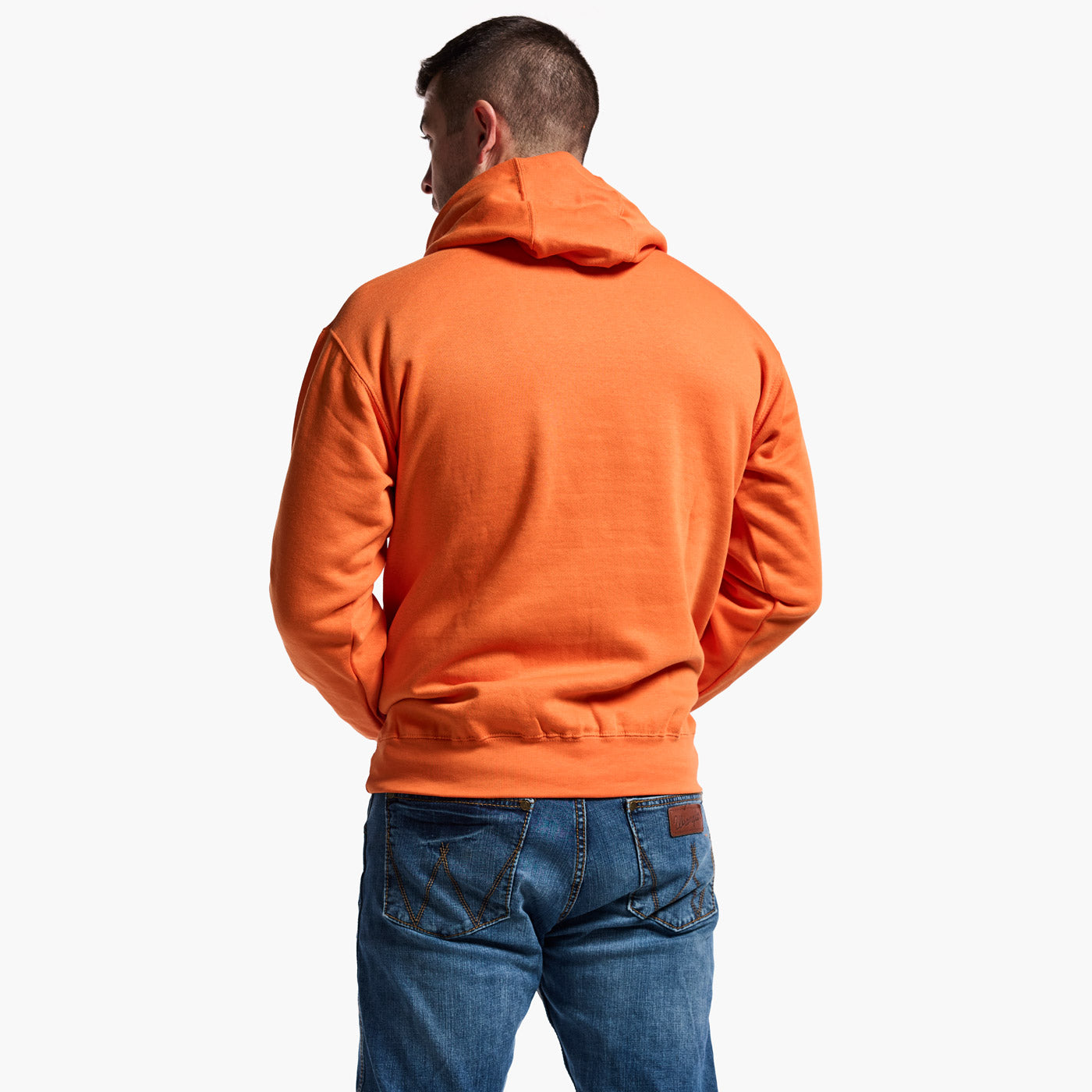 Person wearing an orange hoodie and blue jeans on a white background