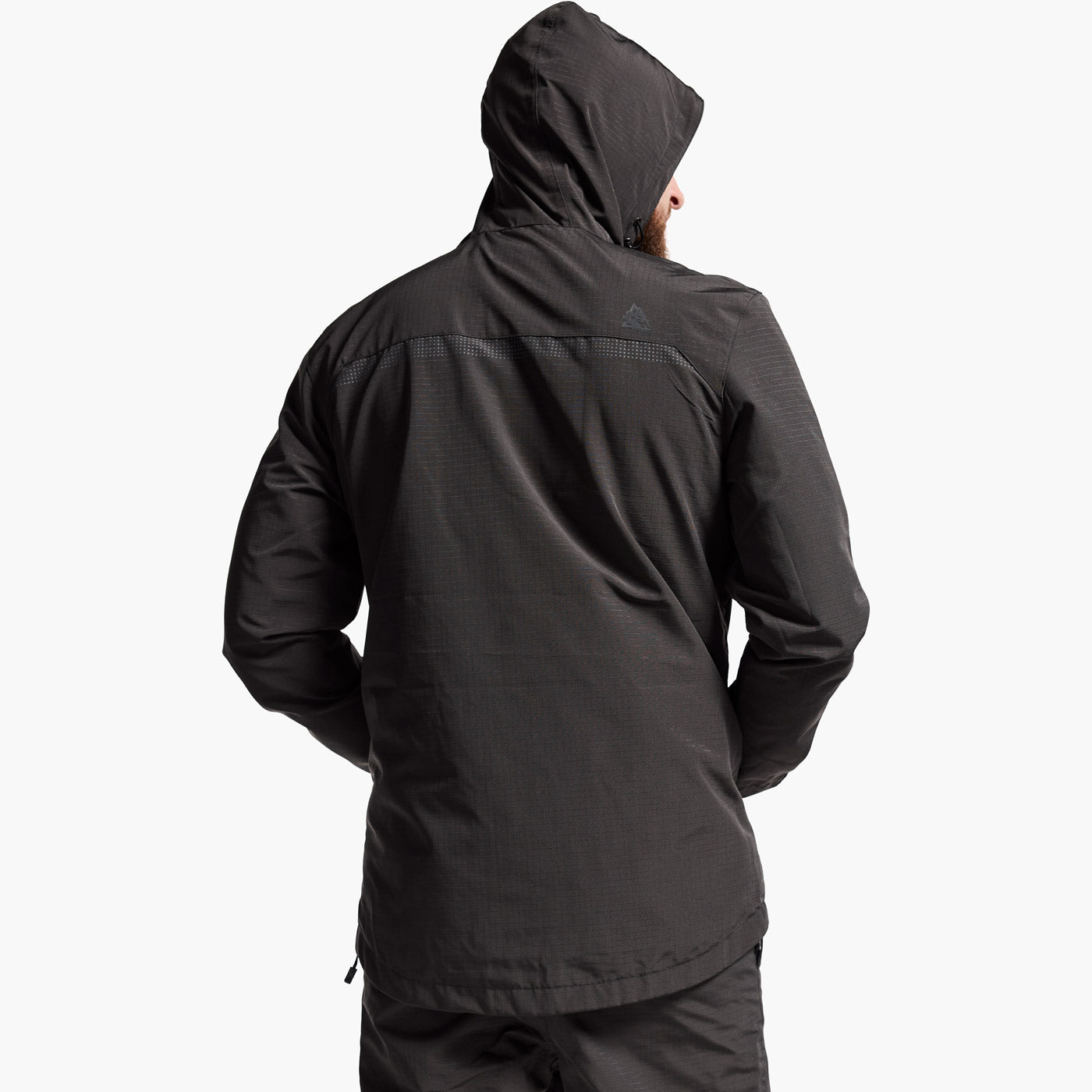 Person wearing a black jacket with a hood on a white background