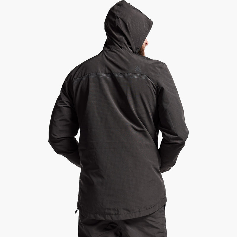 Person wearing a black jacket with a hood on a white background