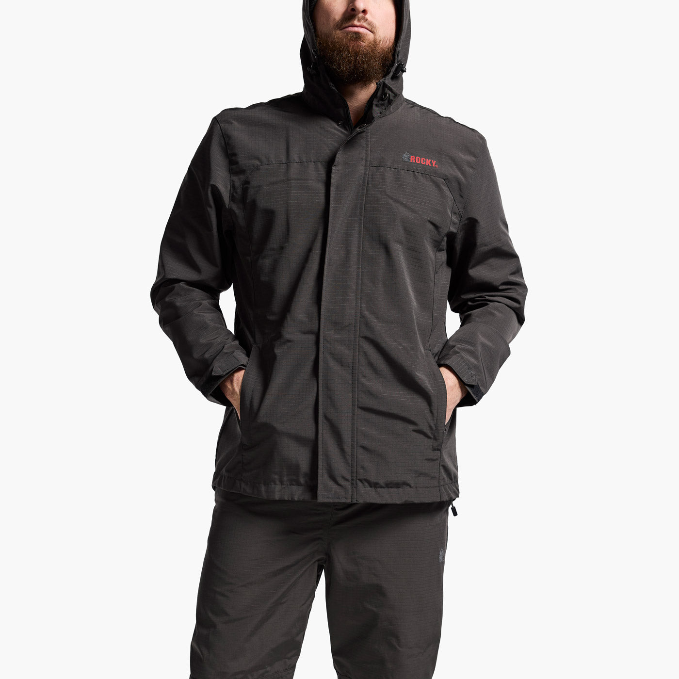 Person wearing a black raincoat with a visible brand logo on a white background